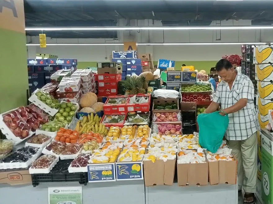 Wholesale fruit stall with apples, mangoes and oranges at Al Aweer Market, Dubai